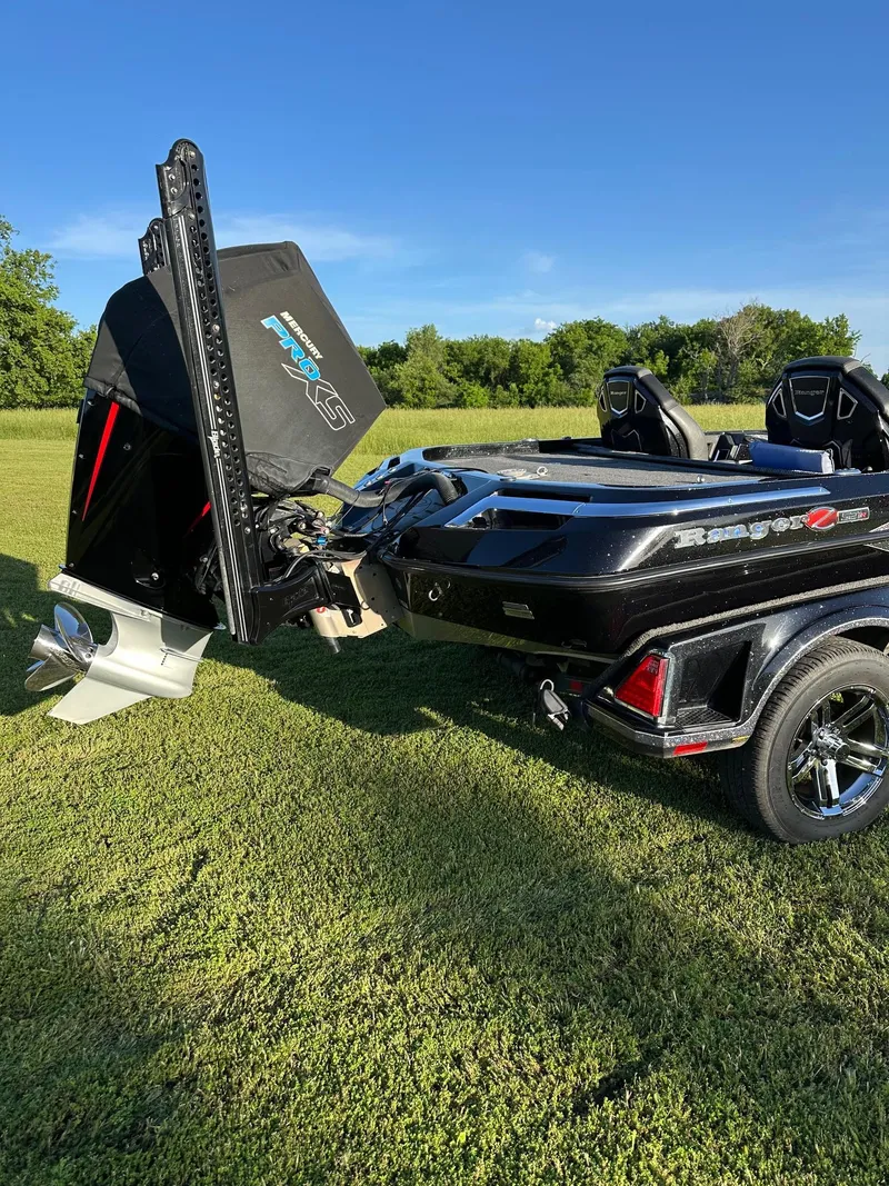 Slide: The Image of 2023 Ranger Z521R boat on grass, showcasing powerful motor and sleek design. - 7