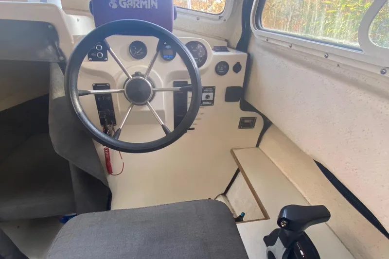 Slide: The Image of Interior helm of a 2002 C-Dory 25' Cruiser with steering wheel and controls. - 10