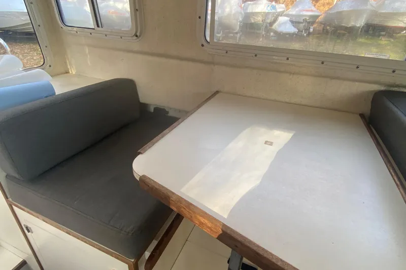 Slide: The Image of Interior of a 2002 C-Dory 25' Cruiser with table and seating. - 15