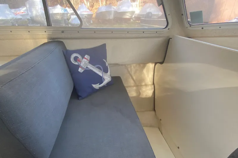Slide: The Image of Interior of 2002 C-Dory 25' Cruiser with anchor-themed pillow on blue seat. - 16