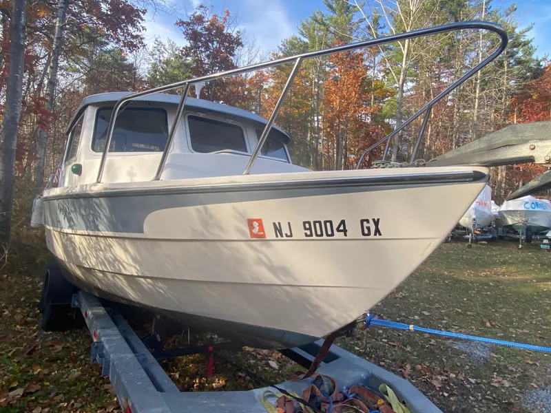 Slide: The Image of 2002 C-Dory 25' Cruiser on trailer, surrounded by autumn trees. - 2