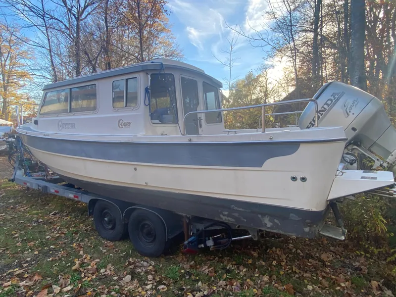 Slide: The Image of 2002 C-Dory 25' Cruiser boat on trailer, surrounded by autumn trees. - 5