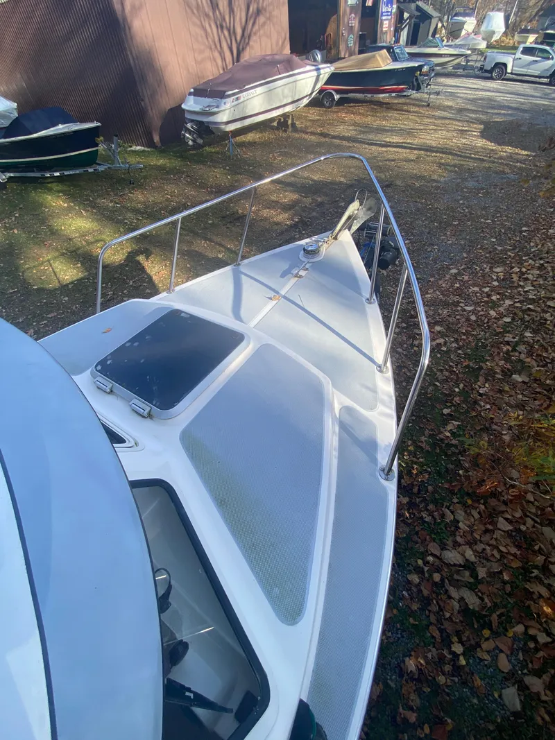 Slide: The Image of 2002 C-Dory 25' Cruiser boat on land, surrounded by other boats and autumn leaves. - 6