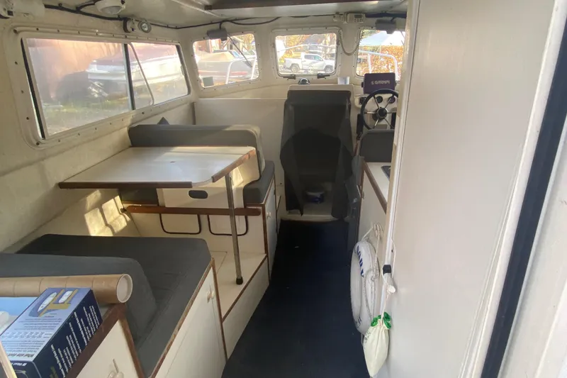 Slide: The Image of Interior of a 2002 C-Dory 25' Cruiser boat with seating and table. - 9