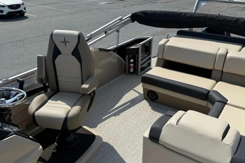 Slide: The Image of 2025 Berkshire 23CL STS 3.0 boat interior with beige seating and steering wheel. - 10