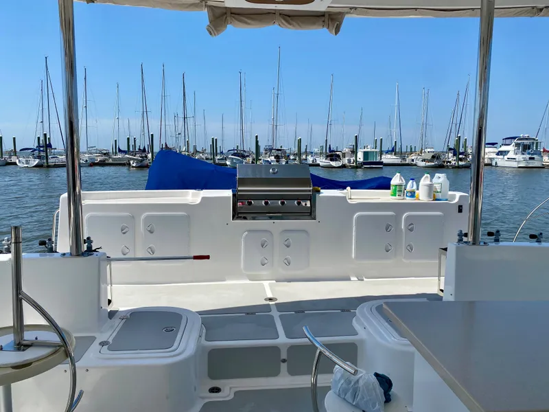 Slide: The Image of Royal Cape Catamarans 530, 2019 model, docked with marina view and outdoor seating area. - 11