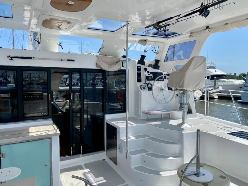 Slide: The Image of 2019 Royal Cape Catamarans 530 cockpit with helm, seating, and marina view. - 13