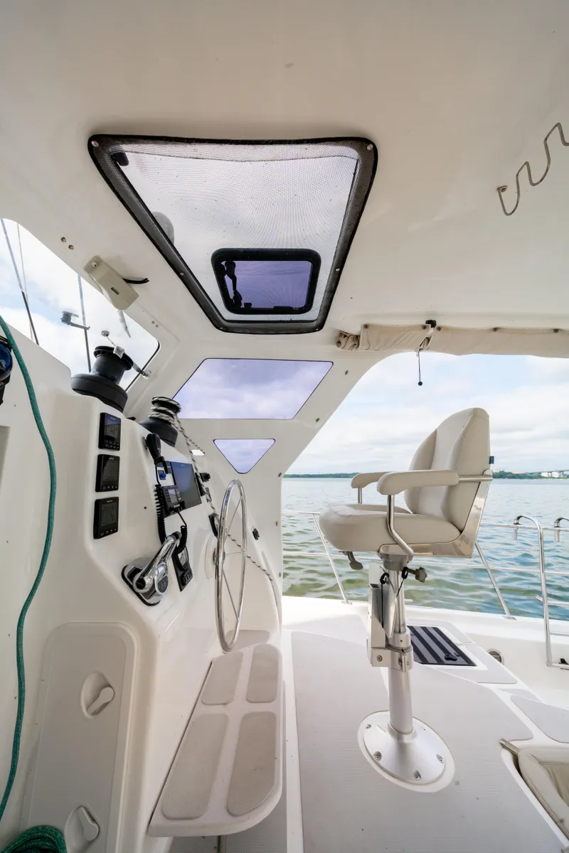 Slide: The Image of Cockpit of 2019 Royal Cape Catamarans Majestic 530 with steering wheel and captain's chair. - 14