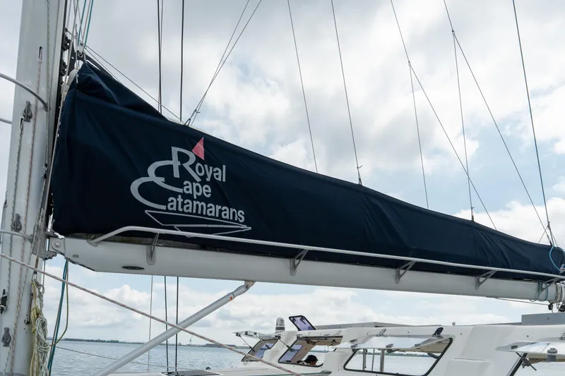 Slide: The Image of Royal Cape Catamarans Majestic 530 sailboat, 2019 model, with covered boom against cloudy sky. - 16