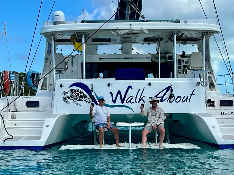 Slide: The Image of 2019 Royal Cape Catamarans 530, "Walk About," with two people relaxing on the deck. - 23