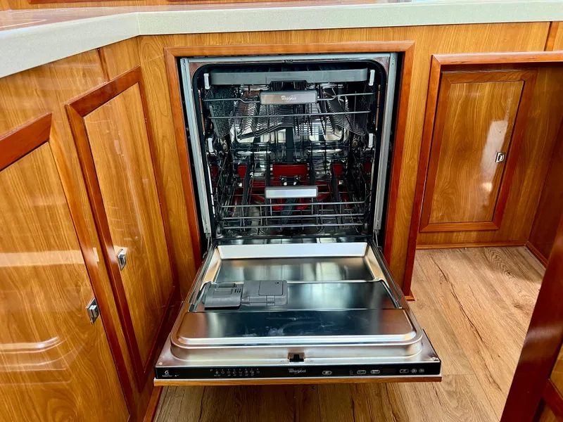 Slide: The Image of Open dishwasher in 2019 Royal Cape Catamarans 530, surrounded by wooden cabinetry. - 34