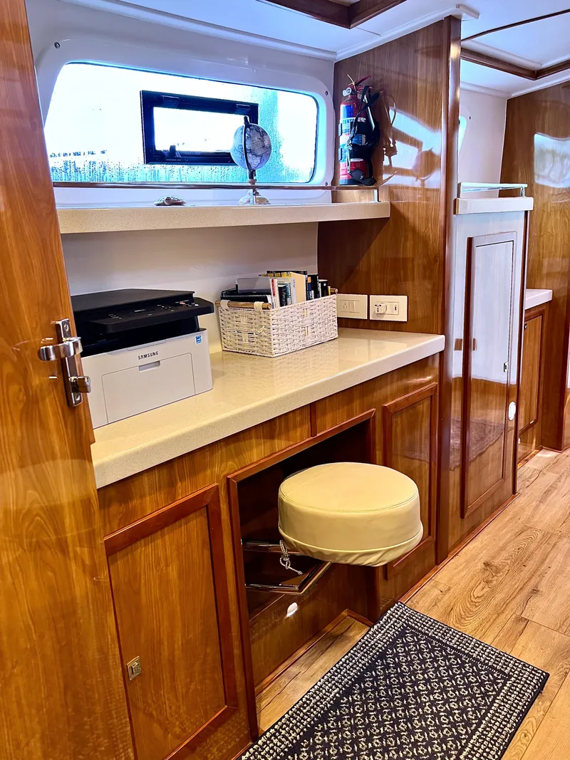 Slide: The Image of Interior of 2019 Royal Cape Catamarans 530 with wooden cabinetry and office setup. - 44