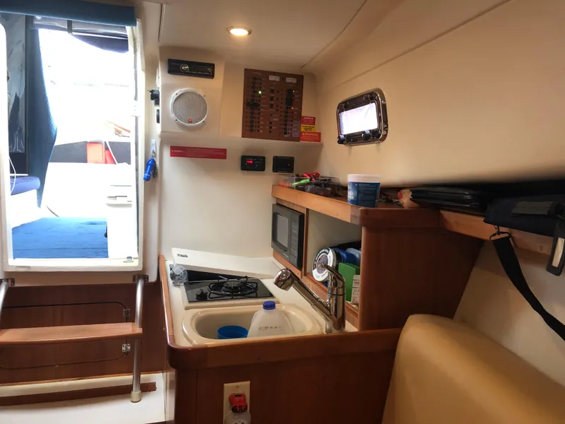 Slide: The Image of 2004 Mainship Pilot 30-II Sedan interior with kitchenette and control panel. - 11