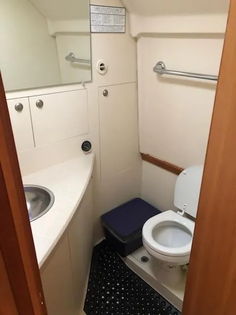 Slide: The Image of 2004 Mainship Pilot 30-II Sedan bathroom with sink, toilet, and storage cabinets. - 12