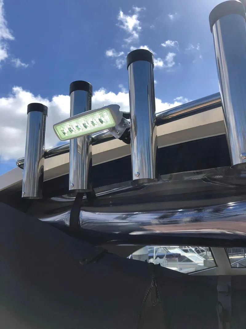 Slide: The Image of 2004 Mainship Pilot 30-II Sedan boat with rod holders and LED light under blue sky. - 16