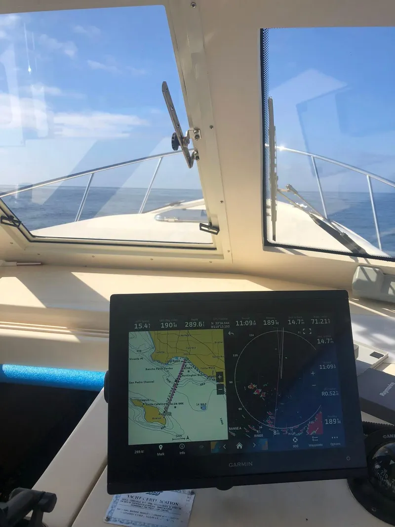 Slide: The Image of 2004 Mainship Pilot 30-II Sedan cockpit with navigation display and ocean view. - 17