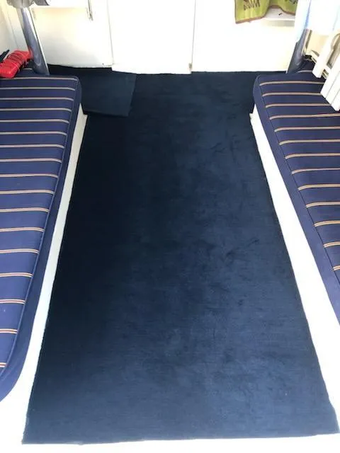 Slide: The Image of Interior of 2004 Mainship Pilot 30-II Sedan with blue carpet and striped seating. - 5