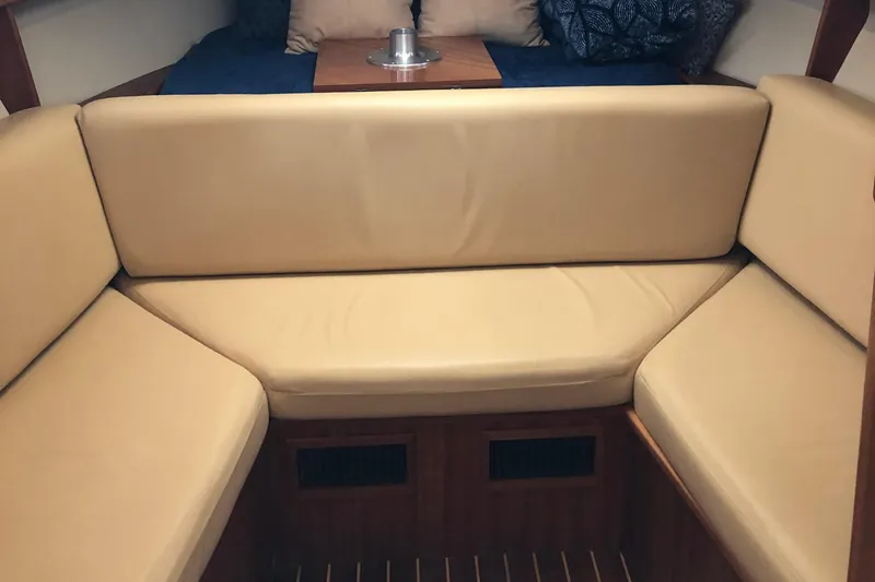 Slide: The Image of 2004 Mainship Pilot 30-II Sedan interior with beige seating and wooden accents. - 8