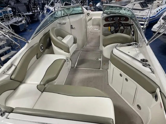 Slide: The Image of 2006 Sea Ray 240 Sundeck interior with beige seating and steering console. - 3