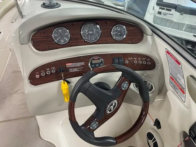 Slide: The Image of 2006 Sea Ray 240 Sundeck dashboard with wood accents and steering wheel. - 6