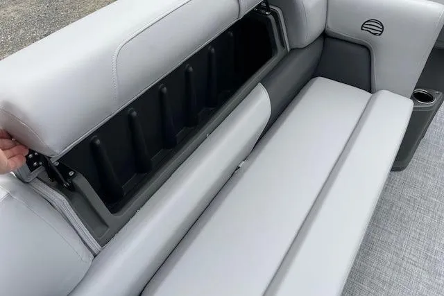Slide: The Image of 2026 Sun Tracker Party Barge 20 DLX interior storage compartment with gray seating. - 14