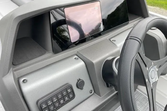 Slide: The Image of 2026 Sun Tracker Party Barge 20 DLX dashboard with steering wheel and control panel. - 16