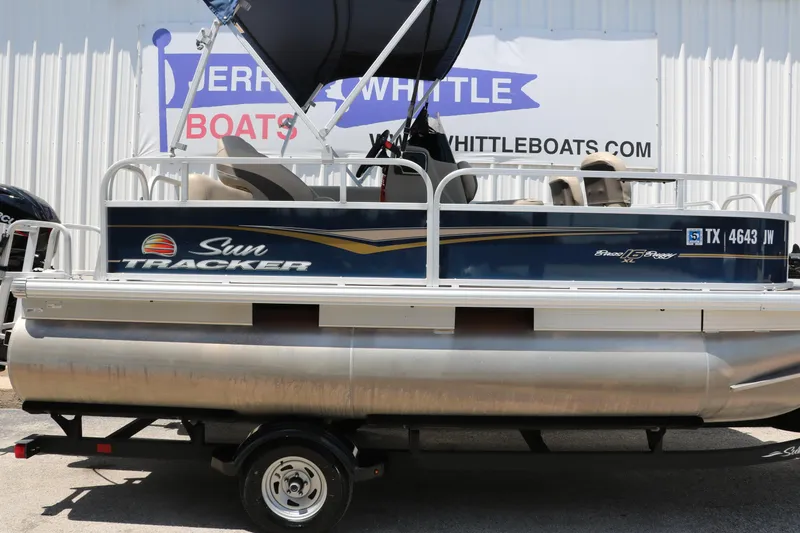 Slide: The Image of 2021 Sun Tracker Bass Buggy 16 XL pontoon boat on trailer, displayed at dealership. - 10