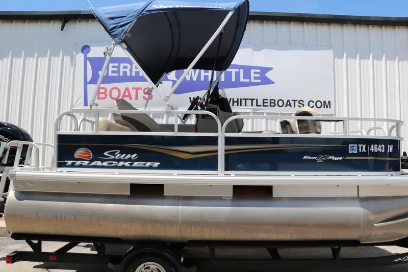 Slide: The Image of 2021 Sun Tracker Bass Buggy 16 XL pontoon boat with canopy, displayed at dealership. - 9