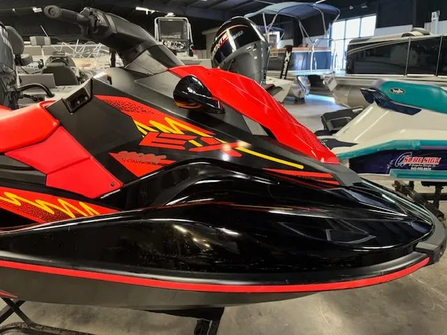 Slide: The Image of 2021 Yamaha WaveRunner EX Sport in vibrant red and black, displayed indoors. - 2