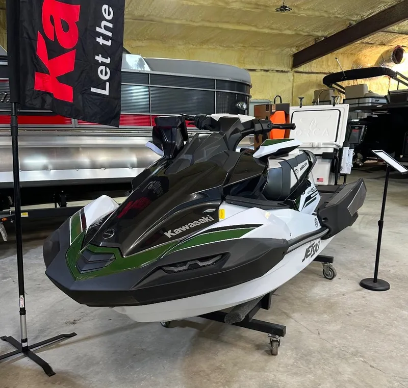 Slide: The Image of 2025 Kawasaki Ultra 160 LXS Angler jet ski with fishing gear setup in showroom. - 4