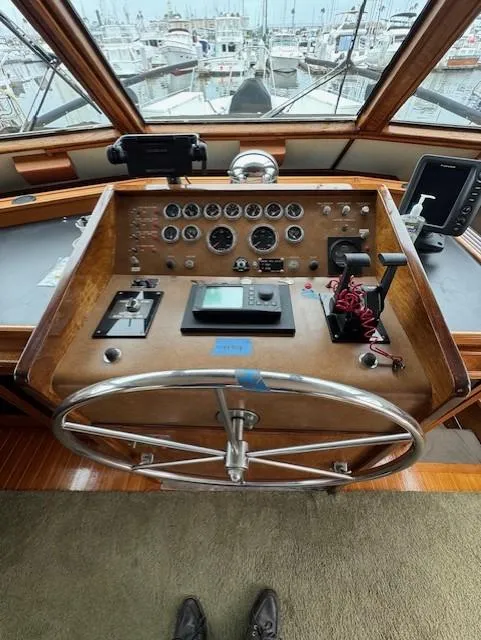 Slide: The Image of 1978 Hatteras 58 Cockpit Motor Yacht helm with gauges, controls, and steering wheel. - 11