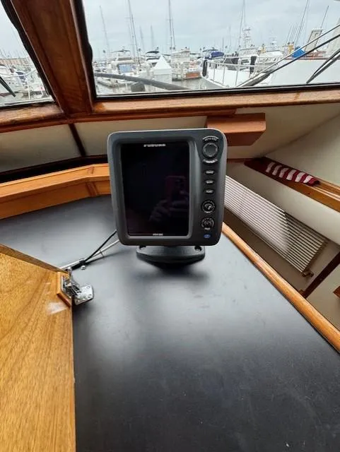 Slide: The Image of 1978 Hatteras 58 Cockpit Motor Yacht helm with navigation equipment and marina view. - 15