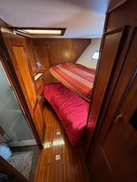 Slide: The Image of 1978 Hatteras 58 Cockpit Motor Yacht cabin with wooden interior and cozy bedding. - 24