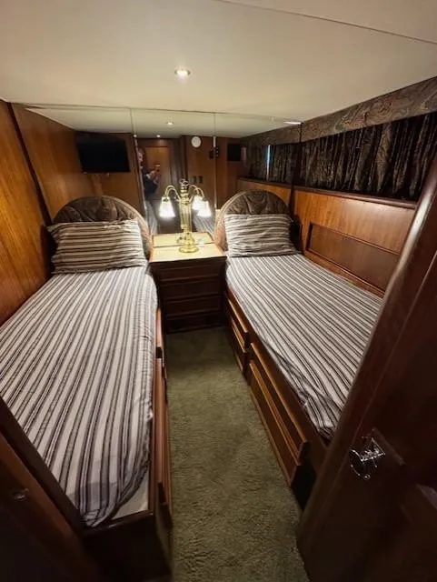 Slide: The Image of 1978 Hatteras 58 Cockpit Motor Yacht cabin with twin beds and wooden interior. - 27