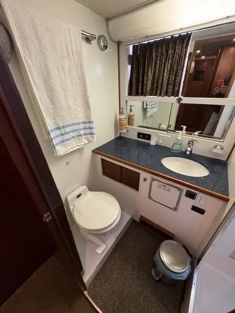 Slide: The Image of 1978 Hatteras 58 Cockpit Motor Yacht bathroom with sink, toilet, and mirror. - 28
