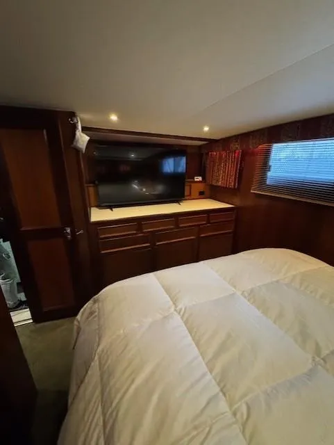 Slide: The Image of Interior of 1978 Hatteras 58 Cockpit Motor Yacht bedroom with TV and wooden cabinetry. - 30