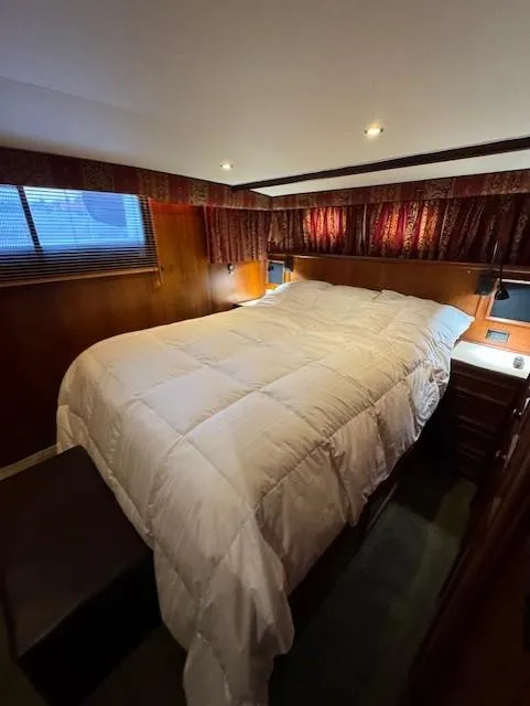 Slide: The Image of Cozy bedroom in 1978 Hatteras 58 Cockpit Motor Yacht with elegant wood paneling. - 31