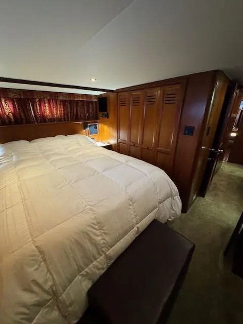 Slide: The Image of Luxurious bedroom in 1978 Hatteras 58 Cockpit Motor Yacht with wood paneling and cozy bedding. - 32