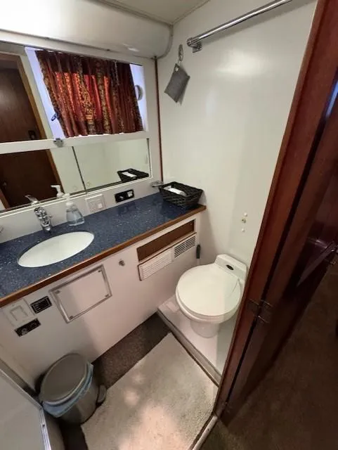 Slide: The Image of 1978 Hatteras 58 Cockpit Motor Yacht bathroom with sink, toilet, and mirror. - 34