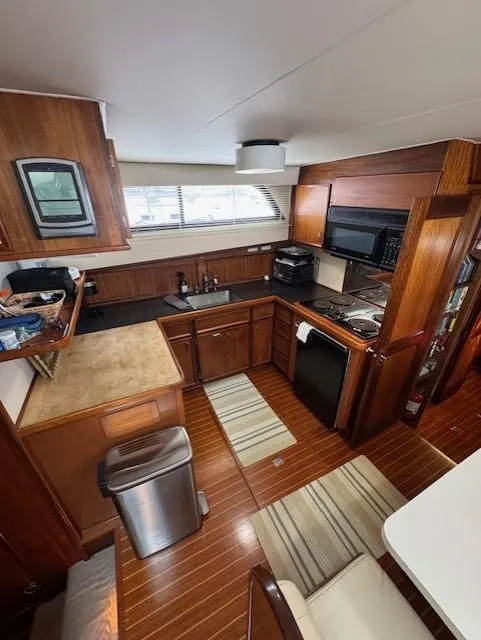 Slide: The Image of 1978 Hatteras 58 Cockpit Motor Yacht kitchen with wood cabinetry and modern appliances. - 36