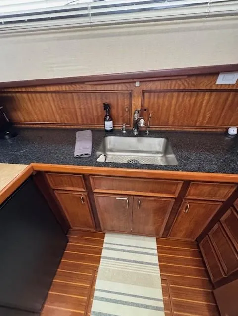 Slide: The Image of 1978 Hatteras 58 Cockpit Motor Yacht kitchen with wooden cabinets and stainless steel sink. - 39