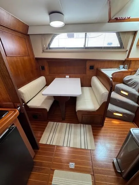 Slide: The Image of 1978 Hatteras 58 Cockpit Motor Yacht interior with dining area and wooden flooring. - 40