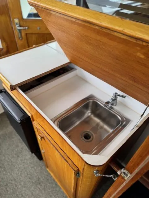 Slide: The Image of 1978 Hatteras 58 Cockpit Motor Yacht galley with wooden cabinetry and stainless steel sink. - 43