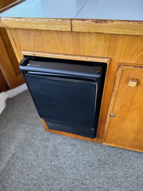 Slide: The Image of 1978 Hatteras 58 Cockpit Motor Yacht interior with built-in U-Line fridge. - 44