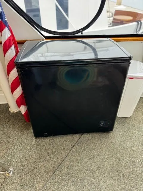 Slide: The Image of Black mini fridge on a 1978 Hatteras 58 Cockpit Motor Yacht, near an American flag. - 45