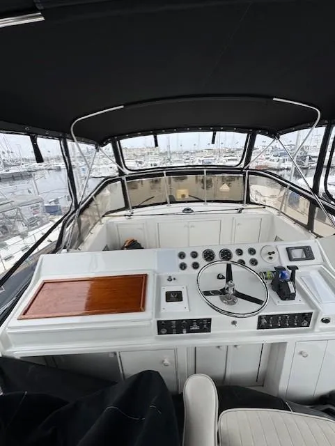 Slide: The Image of 1978 Hatteras 58 Cockpit Motor Yacht helm with controls and steering wheel. - 46