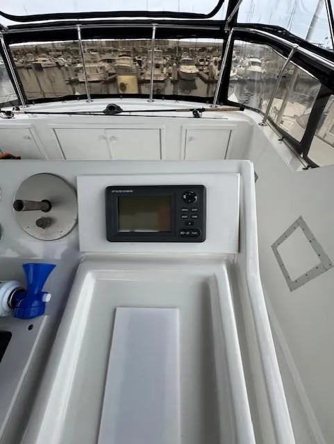 Slide: The Image of 1978 Hatteras 58 Cockpit Motor Yacht helm with navigation equipment and marina view. - 48