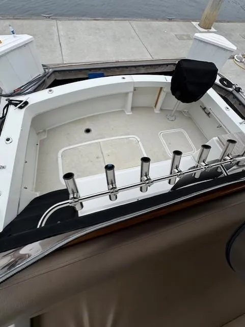 Slide: The Image of 1978 Hatteras 58 Cockpit Motor Yacht docked, showcasing spacious cockpit and rod holders. - 50