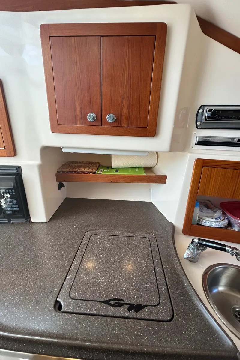 Slide: The Image of 2007 Grady-White Express 305 boat interior with kitchenette, wooden cabinets, and countertop. - 17