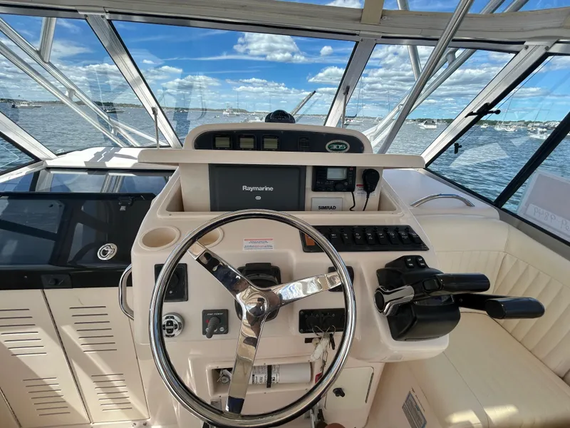 Slide: The Image of 2007 Grady-White Express 305 helm with steering wheel and navigation equipment. - 23